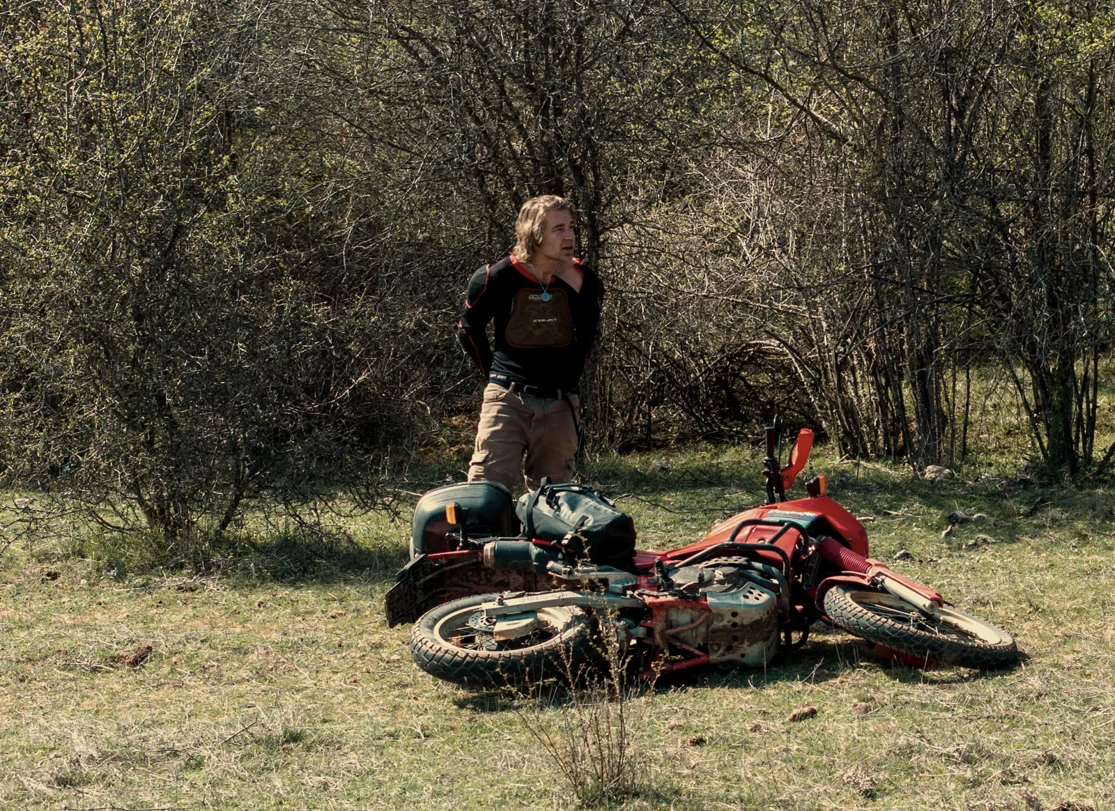 Rider standing beside a motorcycle lying on its side