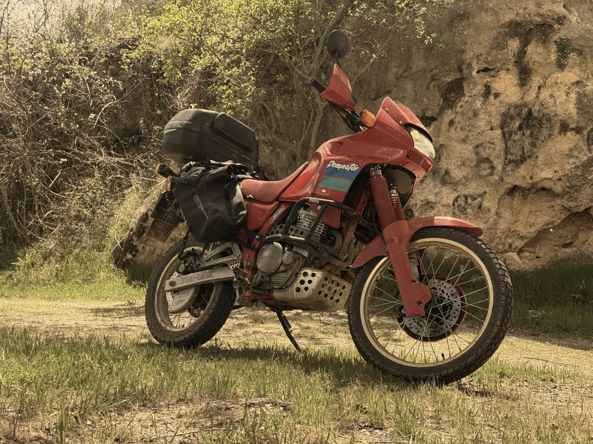 Loaded red Honda Dominator prepared for a journey